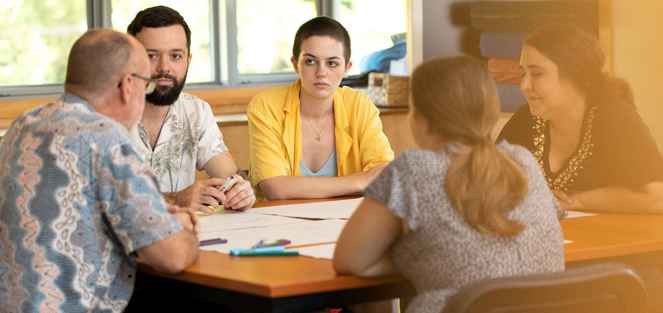 A small group of community members plan an activity around a table.