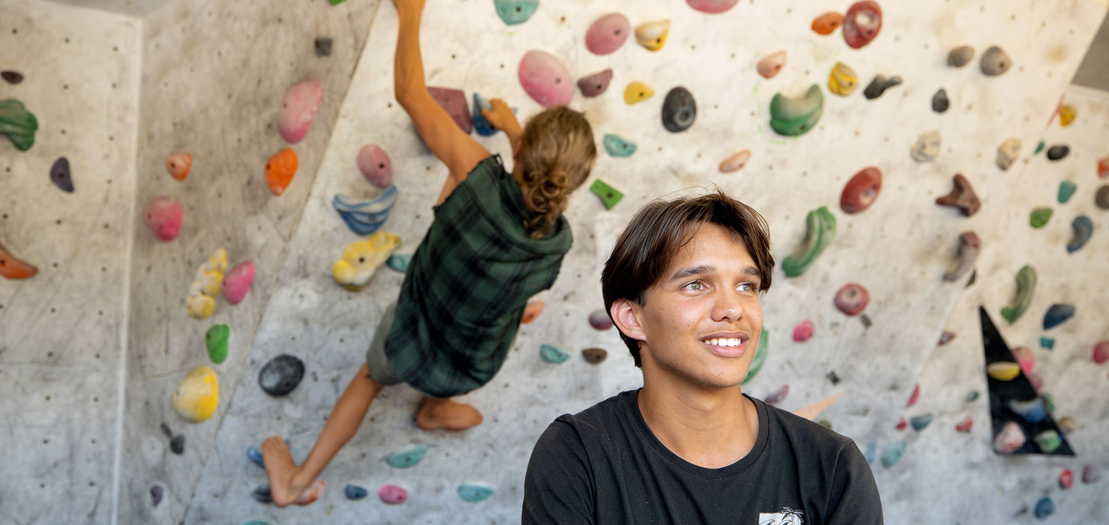 young man with woman on rock wall